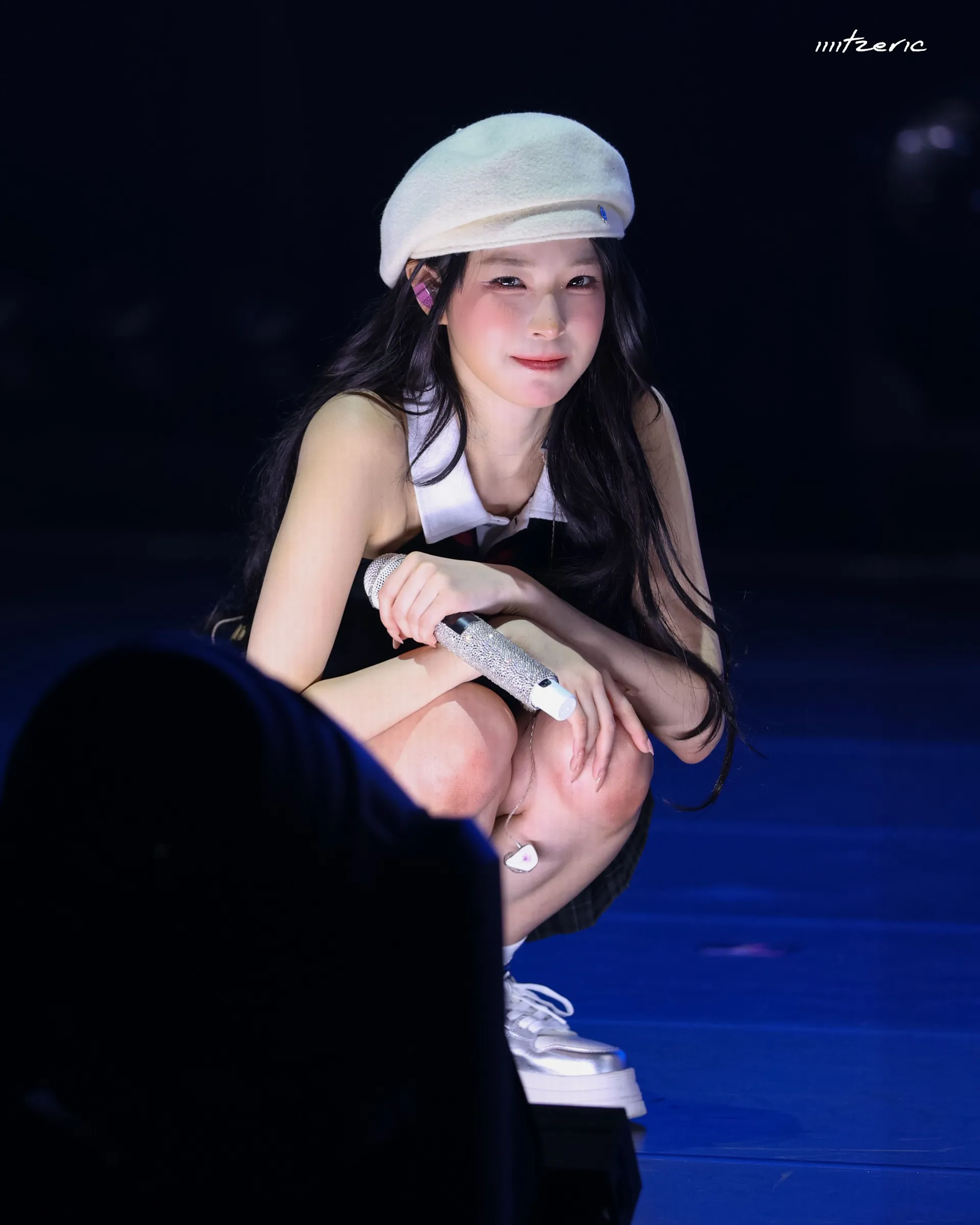 프로미스나인 백지헌 베레모 쓰고 무대 앞에 쪼그려 앉았네